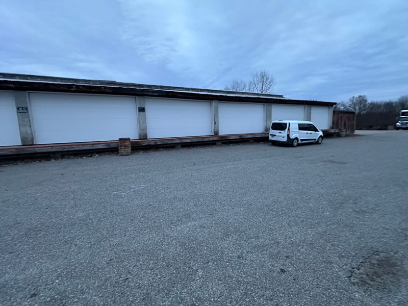Multi-bay storage facility with white doors and Murray service van parked outside