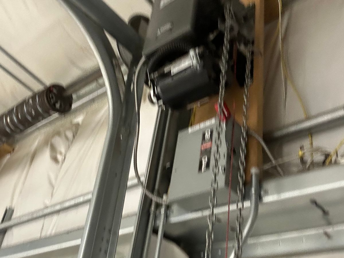 Garage door opener chain drive motor and electrical system mounted on ceiling